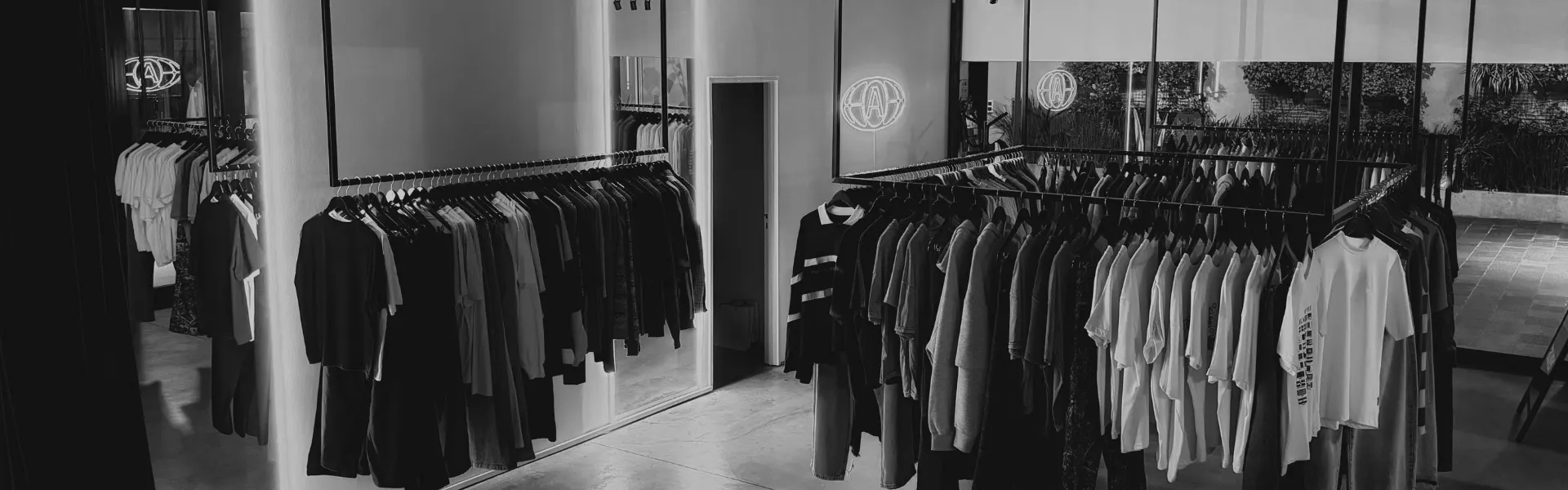 el local por dentro: percheros y el cartel de neón